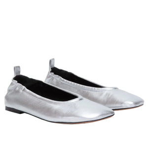 A pair of ID Stretch Back Ballet Flats by 3.1 Phillip Lim, crafted in metallic-silver nappa leather with a glossy finish, featuring black interiors and flat soles, is set against a white background.