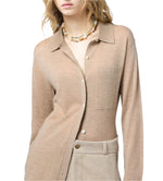 A woman models the Guest in Residence Showtime Cashmere Shirt with a pocket, paired with beige trousers and a colorful beaded necklace, against a white background.