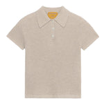 The Shrunken Cashmere Polo by Guest in Residence is a beige, short-sleeve waffle knit shirt made from 100% cashmere, with a pointed collar and three-button placket, shown against a plain background.