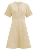 The Sora Dress by Callas Milano is a beige A-line dress made from Italian stretch poplin, featuring short sleeves, a V-neckline, and upper chest seam detail for a sleek silhouette.