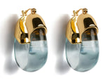 The Lizzie Fortunato Organic Gold Hoops are clear teardrop-shaped glass earrings with rounded gold caps, reminiscent of resin shades, shown against a white background.