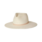The Sherman Hat by Janessa Leone is a cream-colored, wide-brim packable straw fedora with a light beige band and timeless design, shown on a white background.