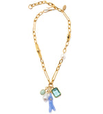The Pacific Reef Necklace by Lizzie Fortunato features a gold bamboo-accented chain adorned with assorted charms, including a coral-shaped piece, a freshwater pearl, a green gem, and an aquamarine crystal baguette.