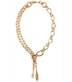 The Spiral Shell Necklace by Lizzie Fortunato features a gold-plated brass lariat design with mixed links and two pendants: a pointed gold charm and a teardrop-shaped charm accented with turquoise.