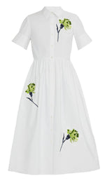 The Erdem Short Sleeve Embroidered Shirt Dress features a white A-line midi design with a button-down front and subtle green floral embroidery on the chest and skirt, offering effortless elegance.