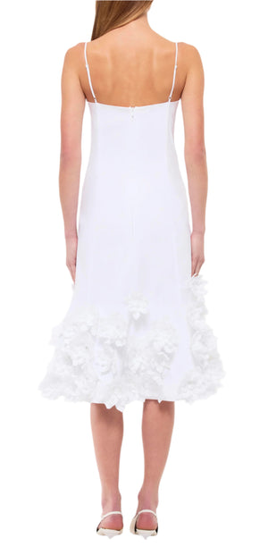 A woman is seen from the back in a Bella Floral Dress by Simkhai, paired with white shoes.