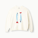 The Staud Giada Sweater is a cream, lightweight summer piece with playful blue and red fish designs, inspired by a sardines jacquard pattern on the front.