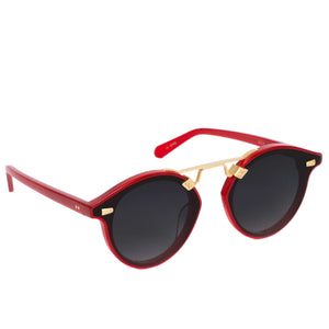 Krewe Nylon Sunglasses feature a red frame, flat nylon lenses with a black tint, and gold accents on the bridge and temples for an oversized look, shown against a white background.