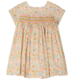 The Bonpoint Baby Girls' and Girls' Maruska Smocked Dress, made with Liberty fabric, features multicolored floral print, hand-embroidered smocking on the chest, short sleeves, and a loose silhouette.