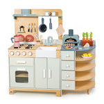 The Tender Leaf Toys La Fiamma Grand Kitchen includes a stove, oven, sink, shelves, play food, utensils, accessories, and a pizza oven arranged on countertops and hooks.