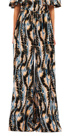 Someone wearing Ulla Johnson's Sawyer Pant, styled in wide-leg fashion and made from 100% silk, featuring an abstract wavy pattern in black, beige, and blue.