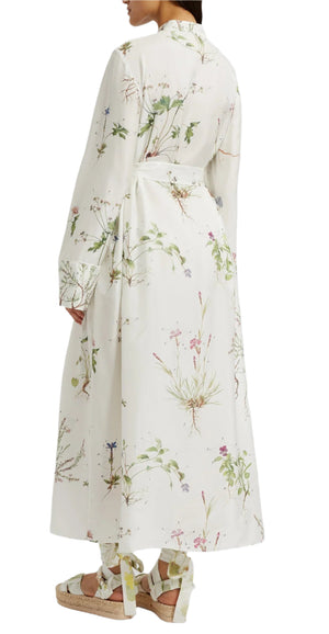 A person is shown from the back wearing the Erdem Long Sleeve Silk Midi Dress With Tie Waist Detail, featuring a light floral print, paired with beige platform sandals with ribbon ties.