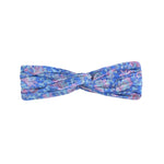 The Girls' Yuriria Headband by Louise Misha features a blue, turban-style design with purple floral patterns and a central knot, elegantly showcased on a white background.