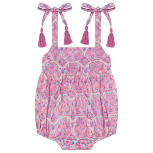 The Mer Baby Girls' Zoe Romper features a pink paisley pattern, shoulder tie accents, and playful tassel details, shown flat on a white background.