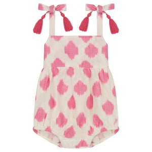 The Mer Baby Girls' Zoe Romper features a pink and white pattern, shoulder tie straps with tassel details, and gathered leg openings.