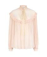 The Blaze Milano Aereine Marwari Blouse is a long-sleeve, light pink silk-blend top with front buttons, ruffled collar and yoke, a neck bow tie, and a billowy silhouette for effortless elegance.