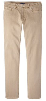 The Peter Millar Fairfield Garment Dyed Denim features beige straight-leg casual pants with button and zip closure, front and back pockets, and cotton stretch fabric, shown laid flat on a white background.