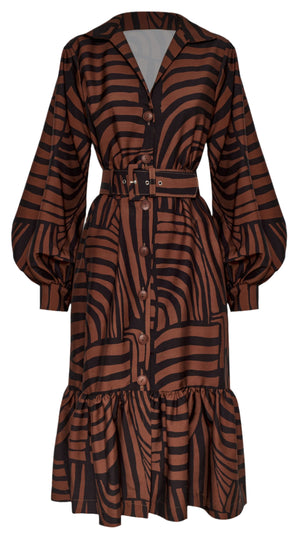 The De Mi Vida Dress by Andres Otalora is a brown and black striped long-sleeve with a button-down front, A-line silhouette, belted waist, point collar, and ruffled hem.