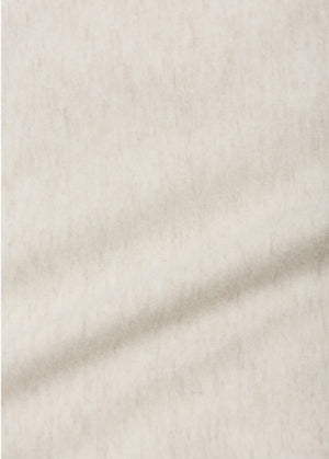 Close-up of the soft, light beige fabric used in the Arsene & Les Pipelettes Baby Golbert T-shirt Cable Car Bio—subtly mottled with a faint diagonal crease, perfect for a cozy baby tee.
