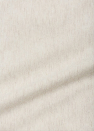 Close-up of the soft, light beige fabric of the Arsene & Les Pipelettes Baby Boys' Gregoire Hockey T-Shirt, featuring a subtle texture and a faint diagonal crease—perfect for your little one.