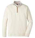 The Peter Millar Artisan Crafted Cashmere Flex Quarter-Zip, inspired by British Isles knitwear, is layered over a collared checkered shirt and laid flat on a white background.