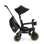 The Doona Liki Trike - Midnight Edition is a black and yellow child tricycle with a sunshade and side storage bag. As a stroller alternative, it offers a compact folding design that grows with your child for convenience at every stage of development.