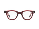 The Caddis Wabi Sabi eyeglasses feature a red tortoiseshell bio-based acetate frame and clear, scratch-resistant lenses, displayed front-facing on a white background.
