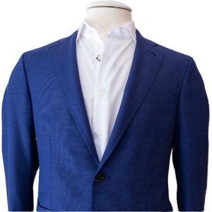 The Canali Blue Sei Blazer, featuring a modern fit and single button design in a luxurious wool silk linen blend, is stylishly paired with a crisp white dress shirt on the mannequin.