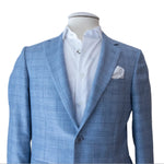Canali's Sky Blue Fine Plaid Blazer and white dress shirt are displayed on a mannequin, showcasing a modern fit with an overcheck pattern and complemented by a crisp white pocket square.
