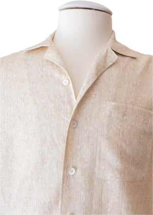 Close-up of the Neutral Abstract Sport Shirt by Canali, a beige short-sleeve button-up made from pure linen with a subtle botanical pattern and open camp collar, displayed on a white mannequin torso.