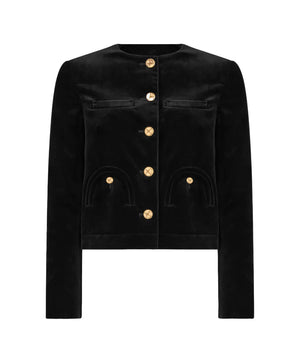 The Jealousy Shamo Bolero by Blaze Milano is a black cotton velvet jacket featuring long sleeves, a round neckline, gold-toned front buttons, and two curved pockets on each side.