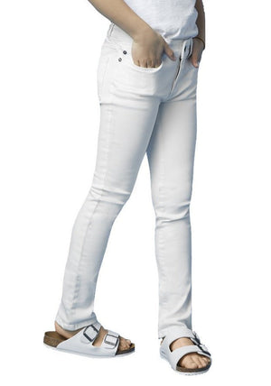 A girl in DL1961's Chloe Skinny Jeans, a white top, and white sandals poses with hands in pockets against a plain background.