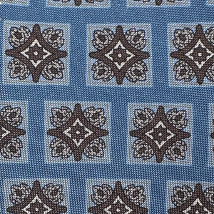 The Robert Jensen Tiled Motif Tie features blue menswear-inspired fabric with a geometric grid of black and white diamond shapes bordered by ornate floral patterns—ideal for a refined, sophisticated look.