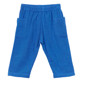 The Arsene & Les Pipelettes Felias Pant is a pair of blue baby trousers made from comfortable cotton veil, featuring an elastic waistband and two front pockets, viewed from the front.