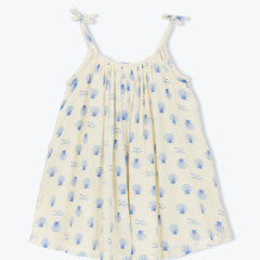 The Girls' Felicidade Dress by Arsene & Les Pipelettes is a sleeveless cream dress with blue seashell print, gathered neckline, and shoulder ribbon ties—ideal for summer, shown on a plain background.