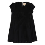The Beaufort Bonnet Company’s Girls' Velveteen Darcy Dress features short sleeves, a black velveteen finish, a front bow detail, and back zipper closure, shown against a white background.