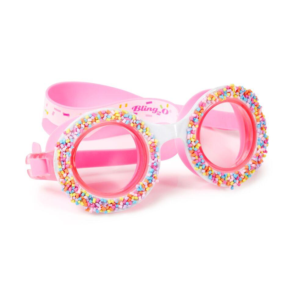 The Bling2O Do-Nuts 4 U Swim Goggles in Boston Creme Pink feature clear lenses, a pink icing-printed strap, a retro round frame, and colorful candy sprinkle decorations for a fun, playful look.
