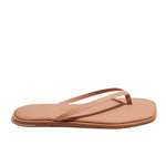 The Tkees Dylan Sandal is a handcrafted tan flip flop with thin straps and a flat sole, made from Brazilian leather, shown in a side view against a white background.