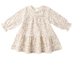 The Quincy Mae Baby Girls' and Girls' Tiered Jersey Dress features long sleeves, a cream color with a light pink floral pattern, a ruffled skirt, and gathered cuffs.