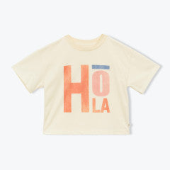 The Girls' Fauvette T-Shirt by Arsene & Les Pipelettes is a cream-colored organic jersey tee featuring "HOLA" in bold, colorful letters on the front.