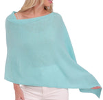 A woman in an Alashan Cashmere turquoise Cashmere Dress Topper Poncho, perfect for day-to-night wardrobe.