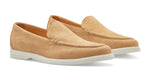 The Excursionist Venetian Loafer by Peter Millar is a pair of tan leather slip-on loafers with a minimalist design and white rubber soles, presented against a pristine white background.