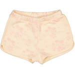 The Girls' Georgia Short by Louis Louise features a tropical palm tree pattern on beige sponge cotton, side pockets, and an elasticated waist for comfort.