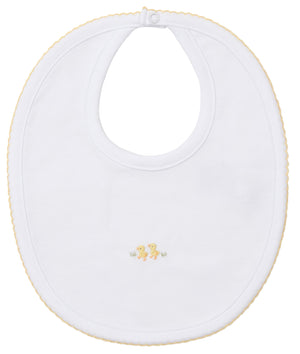 The Kissy Kissy Premier Baby Duckling Bib with Hand Emb. is made from white Pima cotton, featuring yellow trim and two embroidered yellow ducks at the center. A snap closure keeps your baby comfortable and protects from messes.