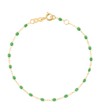 This elegant 18K yellow gold anklet, inspired by the Classic Gigi Bracelet by Gigi Clozeau, features small green beads and a secure clasp, capturing timeless style.