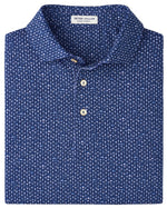 A Sidecar Performance Jersey Polo by Peter Millar, blue with a pattern, four-way stretch, white buttons, UPF 50+ protection, and an inside collar label.