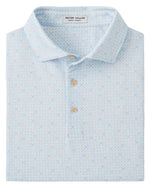 The Peter Millar Castellina Performance Jersey Polo features a light blue geometric pattern, three beige buttons, and four-way stretch fabric for comfort and ease of movement.