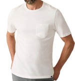 A man in a Faherty Sunwashed Pocket Tee—a plain white, short-sleeve shirt with chest pocket—paired with gray pants, shown shoulders to hips in a relaxed fit.