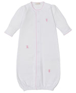 The Kissy Kissy Baby Teddy Bear Time Conv Gown with Hand Emb. is a white long-sleeve gown crafted in soft Peruvian cotton, featuring pink trim, pink teddy bear embroidery, front snaps, and an elastic hem.