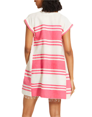 A person is shown from the back wearing the Lemlem Elina Caftan, a hand-woven cotton short dress featuring horizontal pink and white stripes with a fringed hem.
